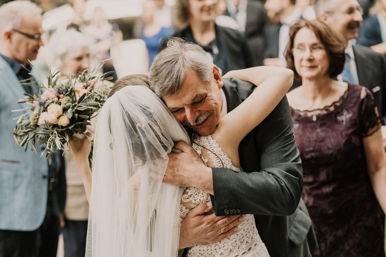 Brautvater umarmt Braut vor Kirche